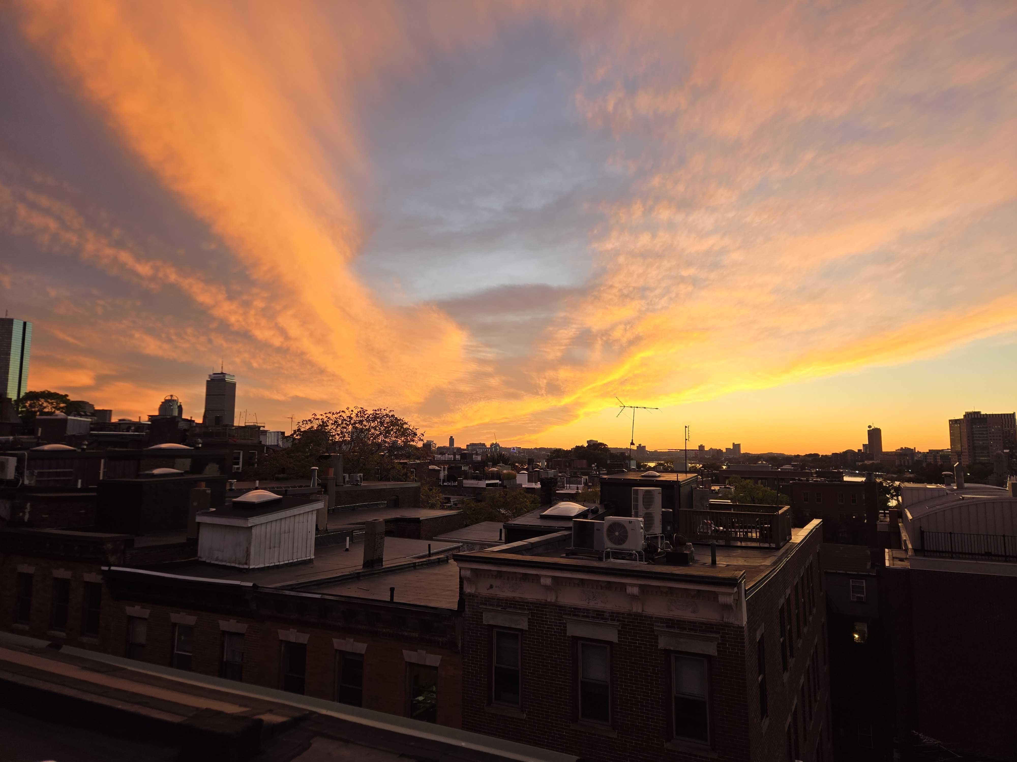 A vibrant sunset over the Boston Beacon Hill skyline.